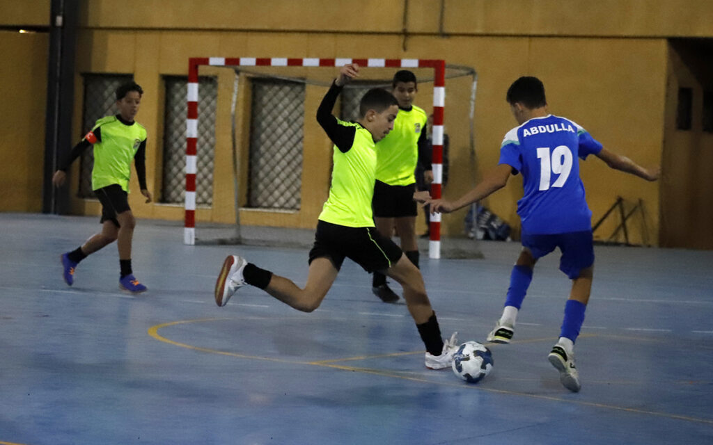 Jugadores compiten en un partido de fútbol sala infantil en el CEIP Constitución.
