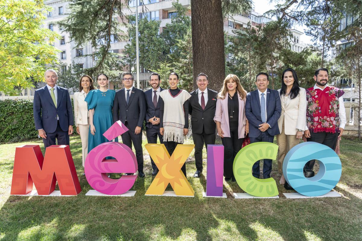 Grupo de personas posando junto a letras coloridas que dicen México