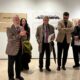 Grupo de personas en una inauguración de exposición de arte en Melilla