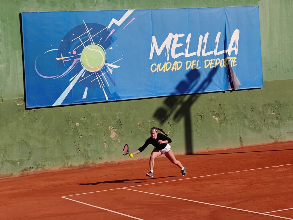 Jugadora de tenis en acción durante un torneo en Melilla