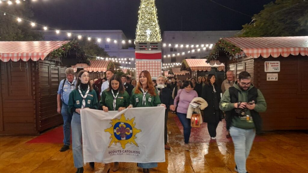 Personas en procesión con la Luz de Belén en Melilla