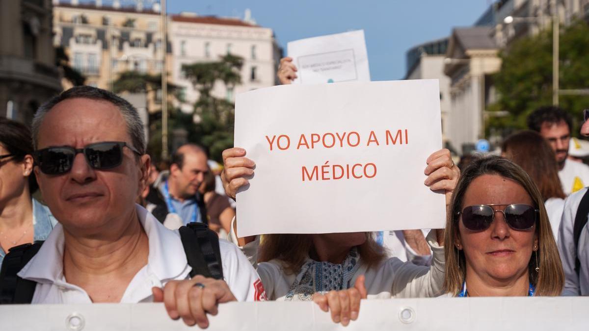 Manifestantes sosteniendo un cartel de apoyo a los médicos durante una huelga.