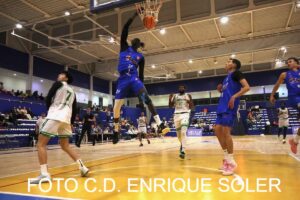 Jugador del Melilla Ciudad del Deporte realizando un mate en un partido de baloncesto