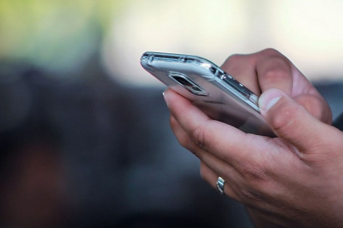 Persona usando un teléfono móvil en un entorno urbano