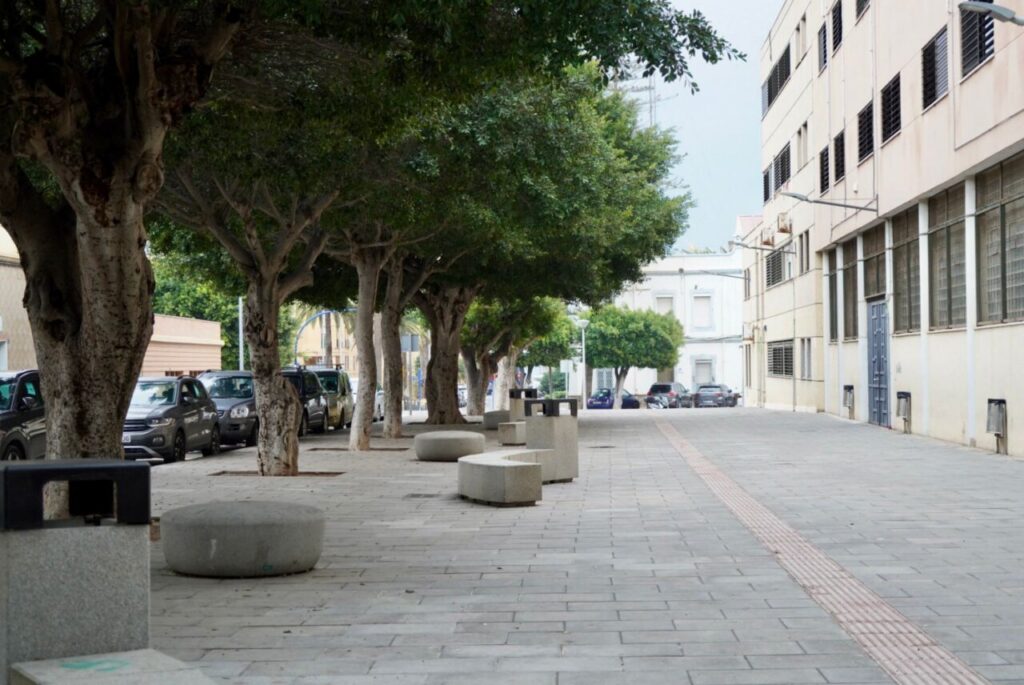 Vista de aceras remodeladas en el barrio del Real con árboles y bancos