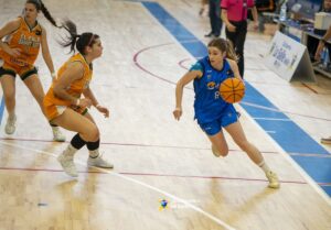 Jugadora del equipo La Salle driblando el balón durante un partido de baloncesto