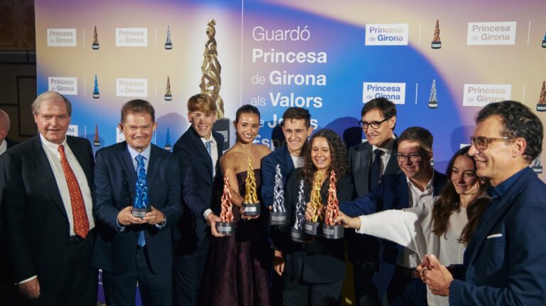 Grupo de personas sosteniendo estatuillas en evento de premios.