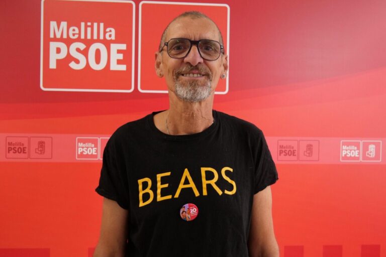 Persona con camiseta negra que dice BEARS en un evento del PSOE en Melilla