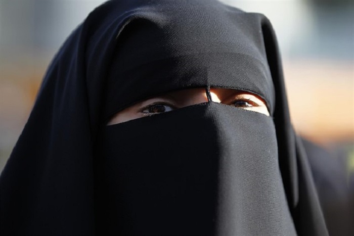 Mujer con niqab que cubre su rostro dejando solo los ojos visibles.