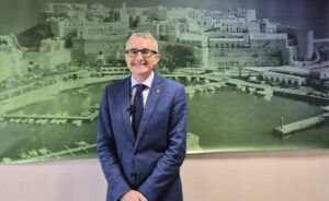 Persona sonriente en traje frente a un fondo de Melilla