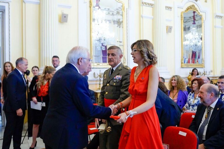 Sabrina y Juanjo intercambiando un saludo en un evento formal.