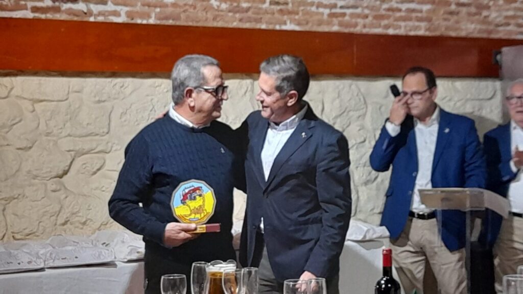 Dos hombres sonriendo durante la copa de Navidad del Club Scorpio Aventuras.