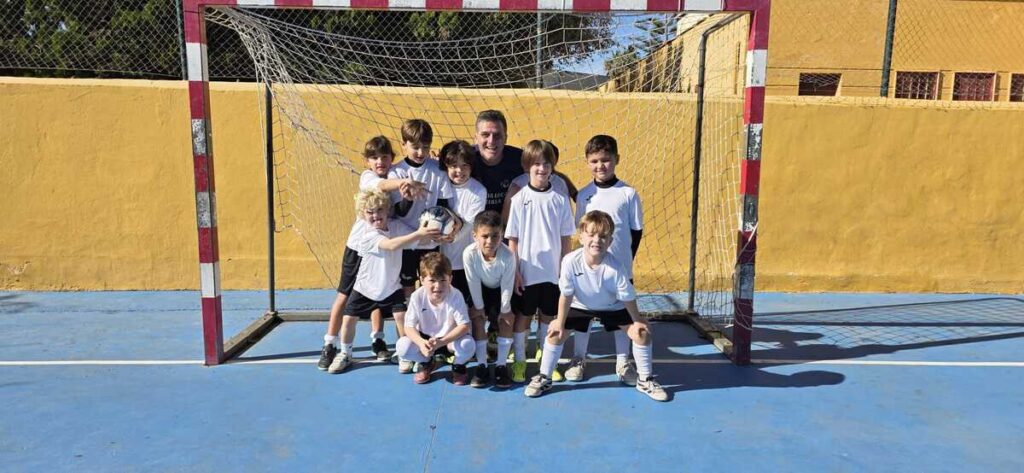 Grupo de niños en el campus de Navidad jugando fútbol sala
