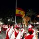 Ceremonia de arriado de bandera en Melilla con participantes en trajes tradicionales.