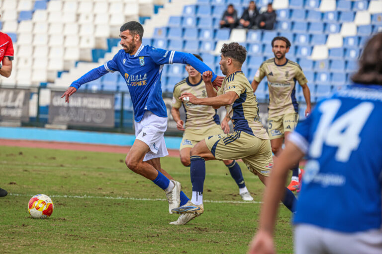 Jugadores de la U.D. Melilla en un partido de fútbol contra el Recreativo.