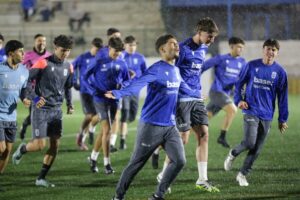 Jugadores juveniles de la U.D. Melilla entrenando bajo la lluvia en el campo
