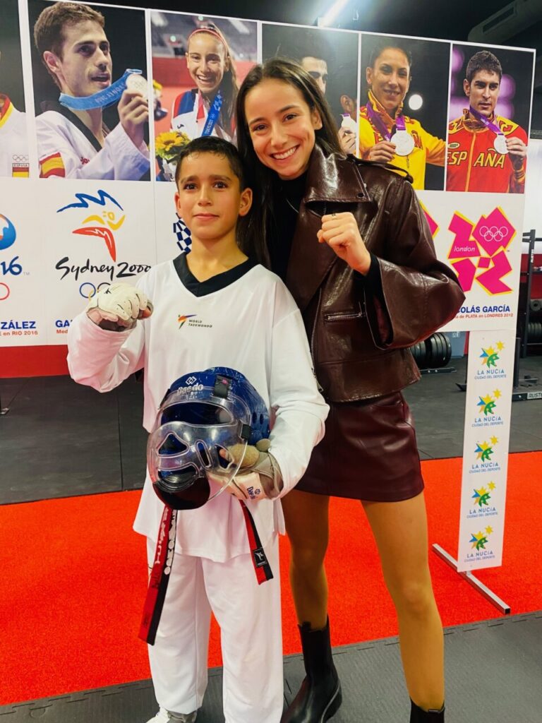 Umaima Assba con un joven deportista en evento de taekwondo
