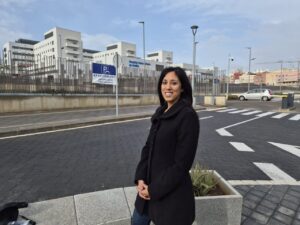 Mujer sonriente frente al nuevo hospital universitario en Melilla