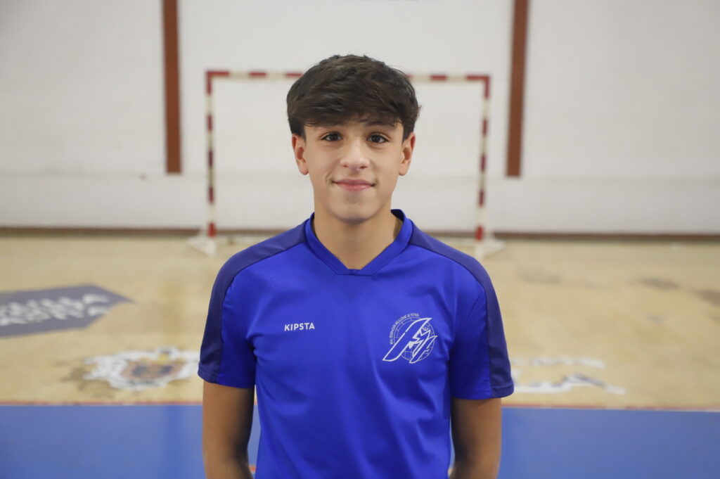 Joven jugador de fútbol sala en uniforme azul en un pabellón deportivo