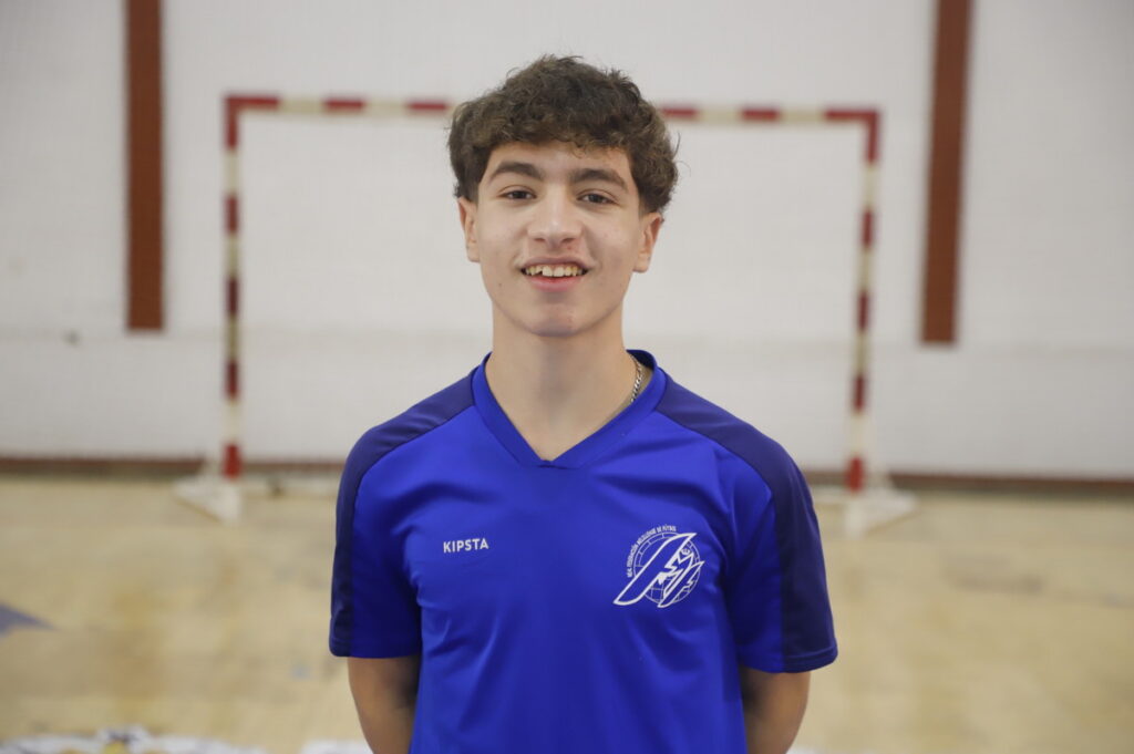 Joven jugador de fútbol sala con camiseta azul en un pabellón deportivo