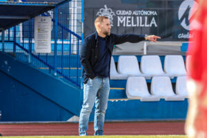 Javi Motos, entrenador de la U.D. Melilla, dirigiendo a su equipo en el campo.