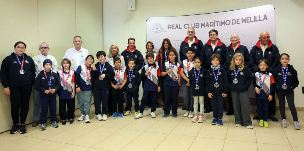 Grupo de niños y adultos con medallas en la entrega de trofeos