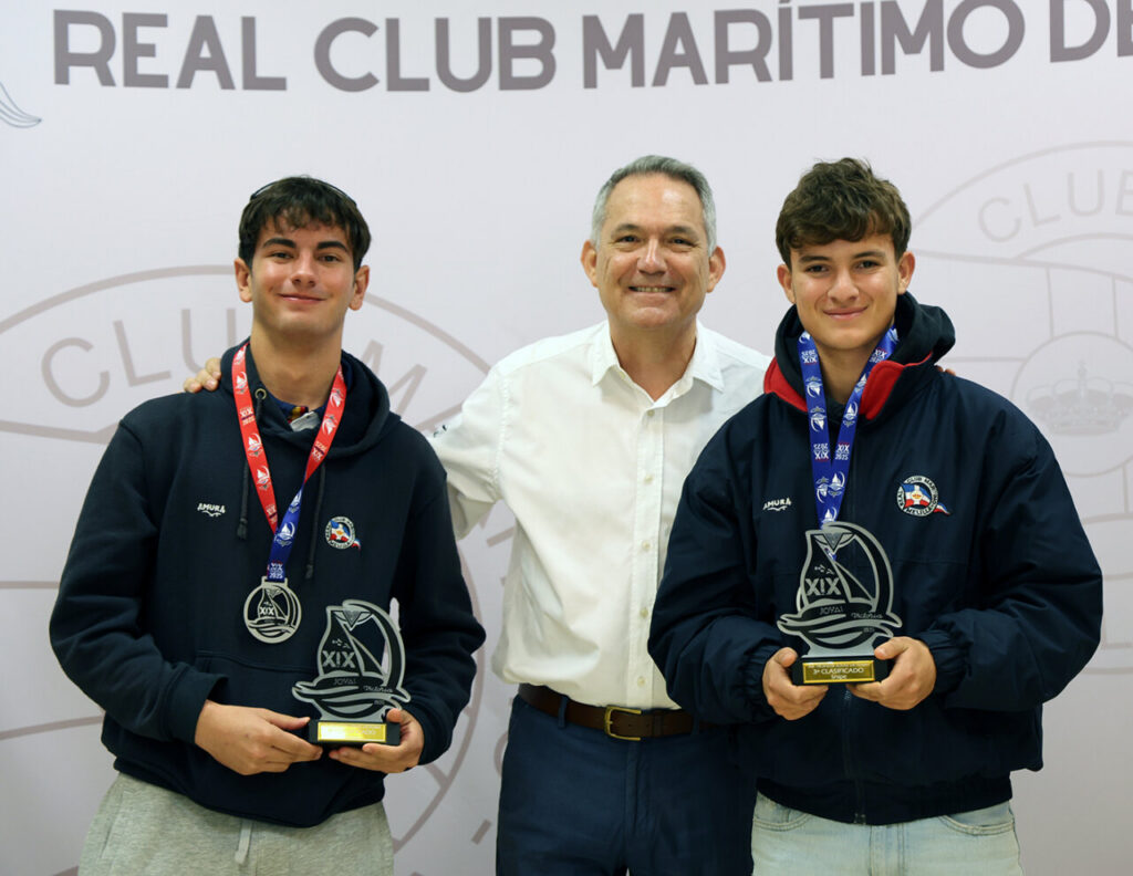 Dos jóvenes regatistas sosteniendo trofeos en el Real Club Marítimo de Melilla.