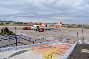 Avión en el aeropuerto de Melilla con vehículos de servicio en la pista.
