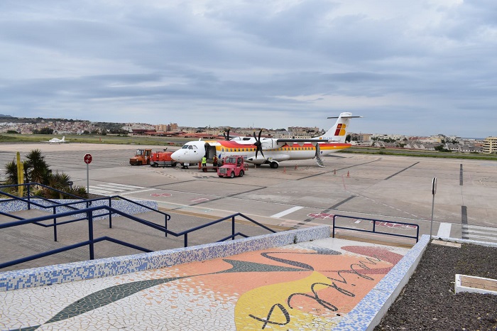 Avión en el aeropuerto de Melilla con vehículos de servicio en la pista.