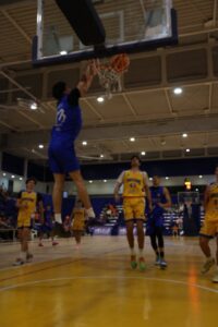 Jugador de baloncesto realizando un mate en un partido