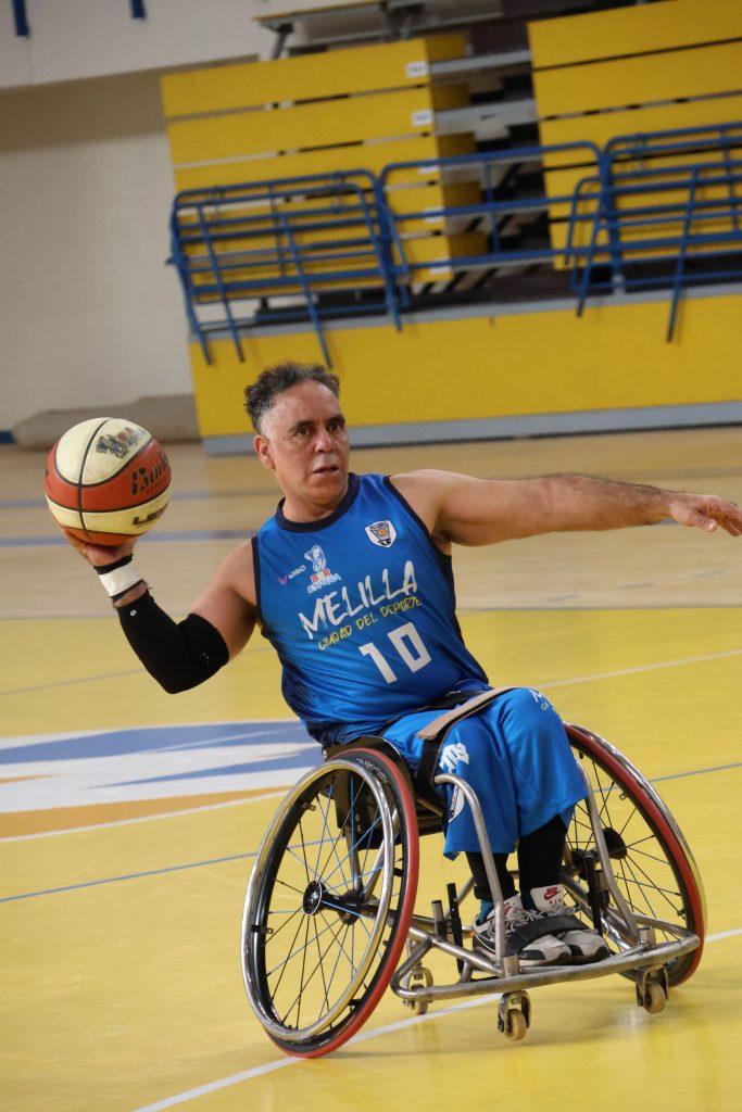 Jugador de baloncesto en silla de ruedas lanzando el balón en la cancha