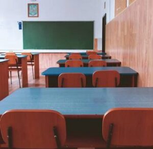 Aulas vacías con escritorios y sillas en un ambiente escolar