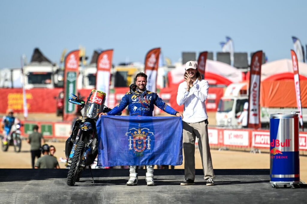 Piloto melillense con bandera en el Dakar 2026 junto a un compañero