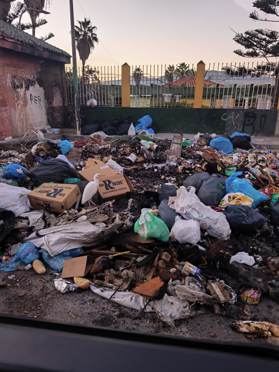 Montón de basura y escombros en un área urbana afectada por vandalismo.