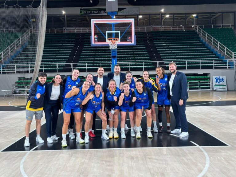 Equipo de baloncesto femenino posando en la cancha tras una victoria