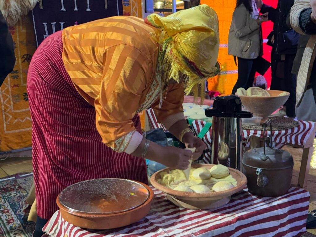 Mujer preparando pan tradicional amazigh en un evento cultural