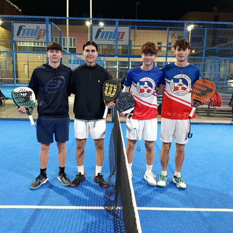 Cuatro jóvenes jugadores de pádel posando en la cancha
