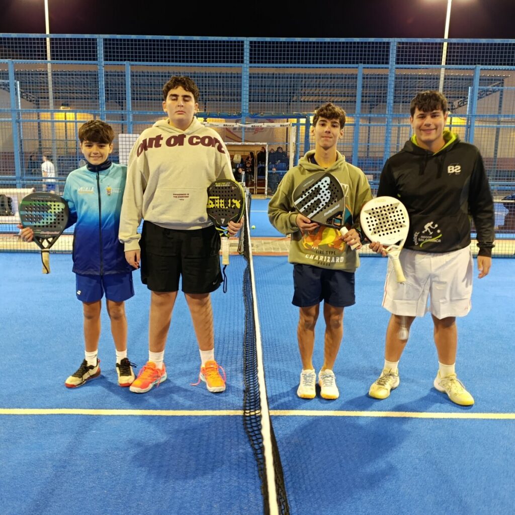 Cuatro jóvenes jugadores de pádel posando en la cancha
