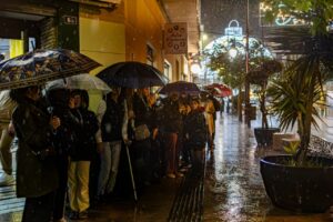 Personas con paraguas esperando bajo la lluvia durante la Cabalgata de Reyes