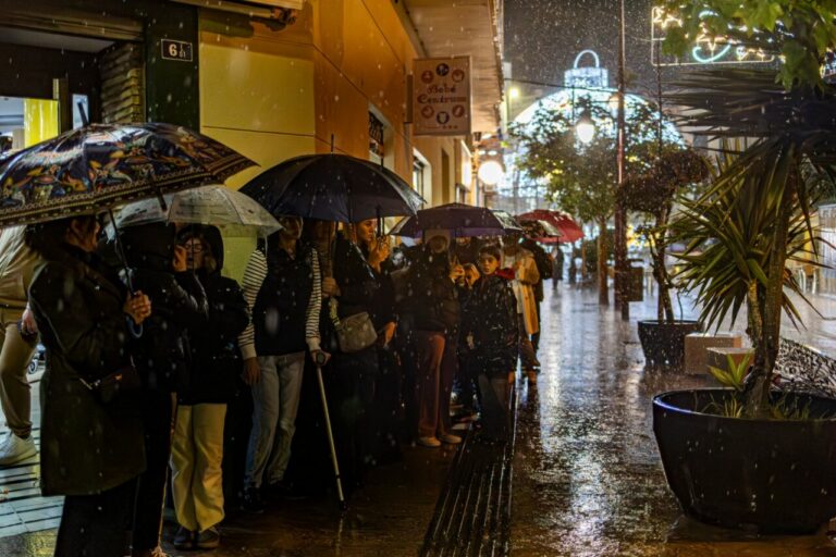 Personas con paraguas esperando bajo la lluvia durante la Cabalgata de Reyes