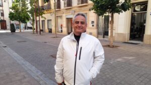 Hombre sonriendo en una calle de Melilla con árboles y edificios de fondo