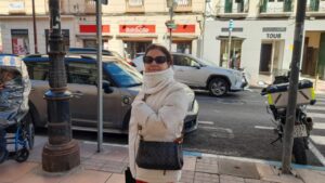 Mujer con abrigo en la calle de Melilla observando el entorno