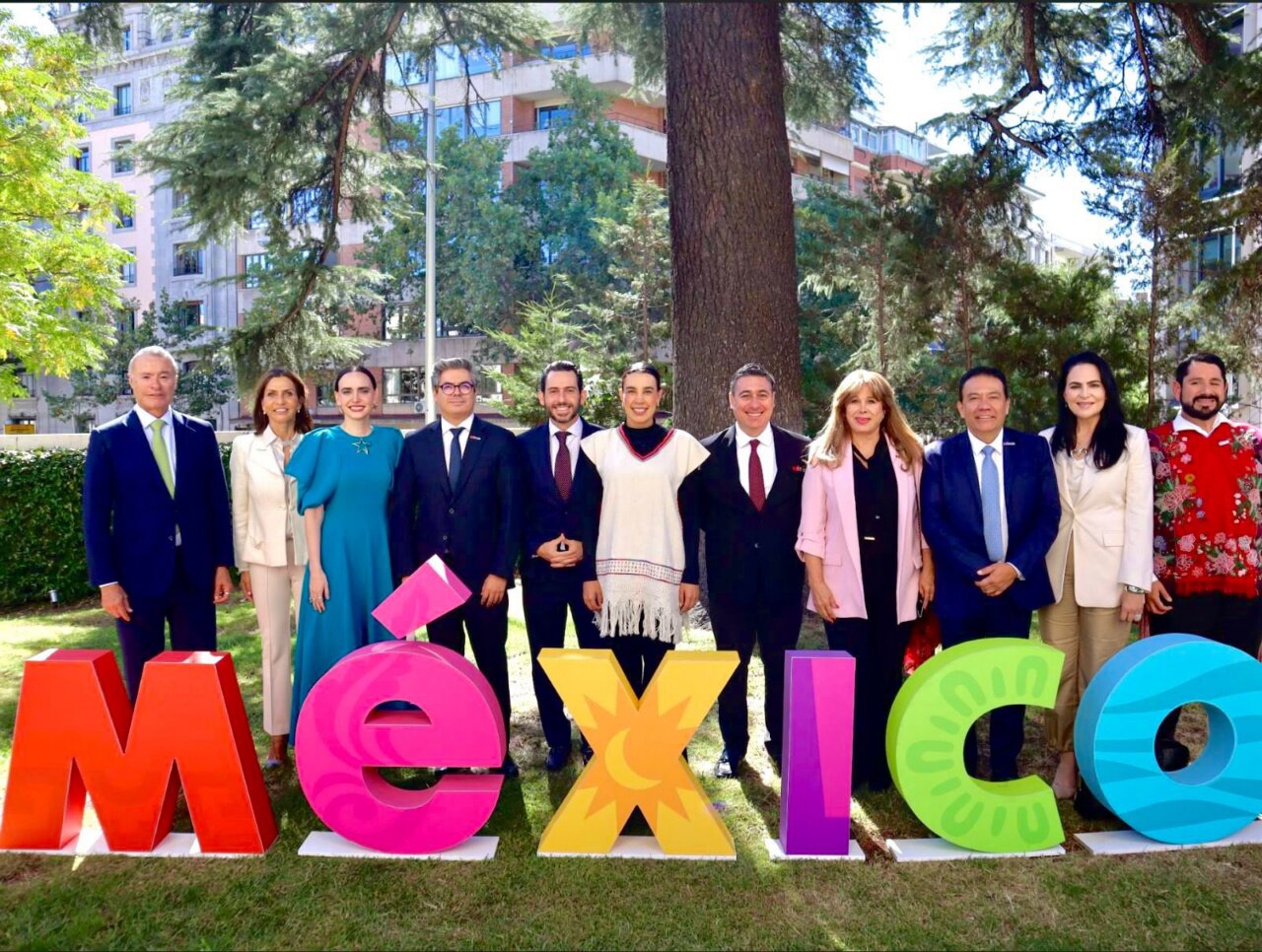 Grupo de personas posando frente a letras coloridas que dicen México