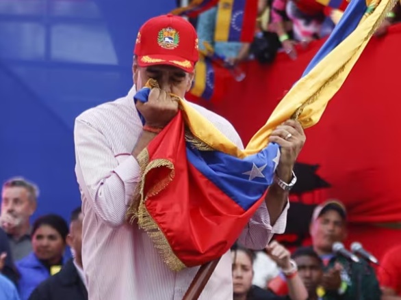 Nicolás Maduro besando la bandera de Venezuela en un evento público