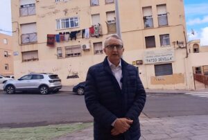 Hombre de pie frente a un edificio en Melilla con ropa tendida