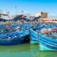 Barcos pesqueros azules en un puerto marroquí bajo un cielo despejado