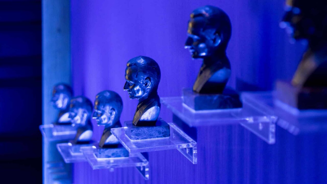 Estatuillas de los Premios Angel Herrera en un fondo azul