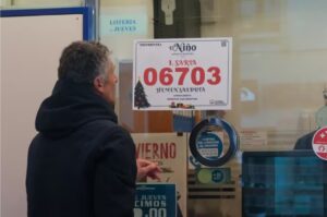 Persona observando el cartel del primer premio del sorteo El Niño 2026