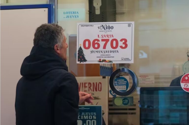 Persona observando el cartel del primer premio del sorteo El Niño 2026