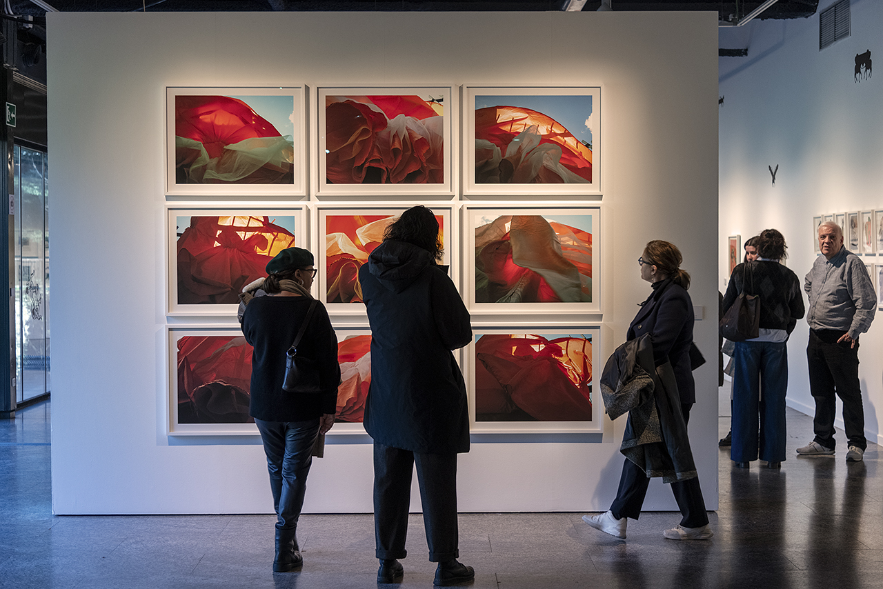 Visitantes observando obras de Quisqueya Henríquez en una exposición en Madrid.